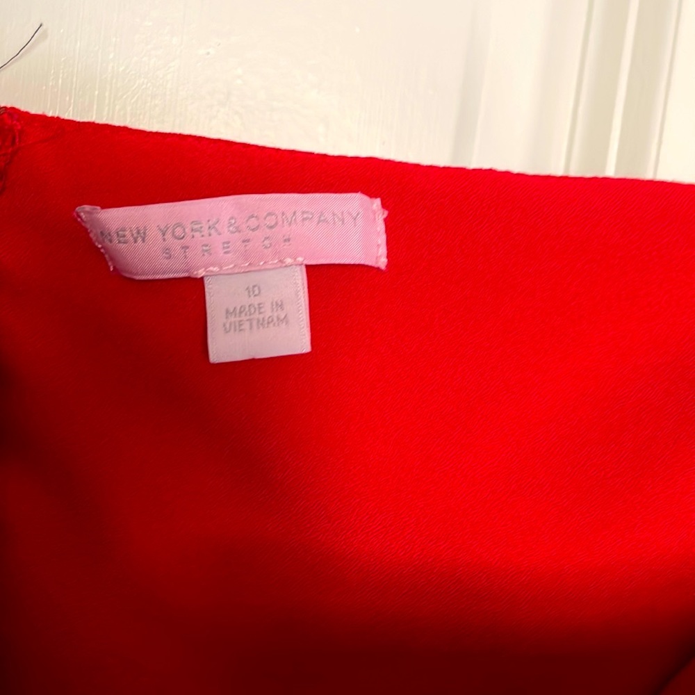 Red strapless jumpsuit with zipper on the back.